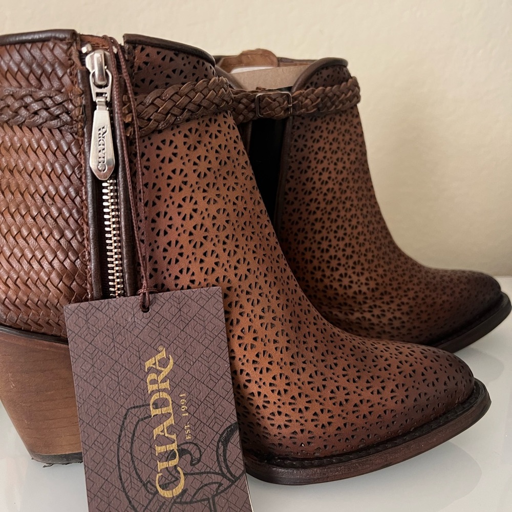 GENUINE BOVINE LEATHER
Perforated brown leather bootie with hand braided strap